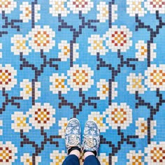 a person standing in front of a colorful tile floor