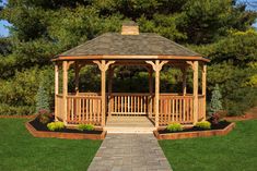 a wooden gazebo sitting on top of a lush green field