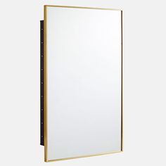 a white and gold framed mirror on the wall with black trim around it's edges