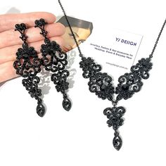 "Gothic black bridal jewelry featuring Victorian wedding Regency vintage stylec chandelier earrings and whimsigoth steampunk statement necklace with ornate damask curls and lace details made of rhinestone crystals in black plating. You may choose earrings only, necklace only or earrings necklace set. Earrings are about 3 3/8\" (8.5cm) long with posts. Necklace total length measures about 17.5\" (44cm). View matching pieces or similar designs at https://etsy.me/3E2xA1t View all Victorian inspired Black And Gold Wedding Necklace, Goth Wedding Necklace, Gothic Prom Jewelry, Black Wedding Necklace, Gothic Wedding Jewelry, Black Wedding Jewelry, Black Crystal Necklace, Victorian Gothic Jewelry, Grey Jewelry