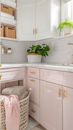 a white kitchen with pink cabinets and gold handles