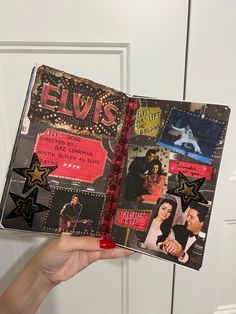 a hand holding an elvis album in front of a white door with black and gold stars