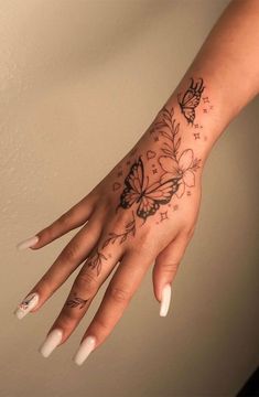 a woman's hand with a butterfly tattoo on it