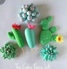 cactus and succulents made out of fondant are arranged on a white surface