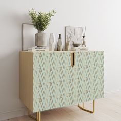 a sideboard with vases and plants on it