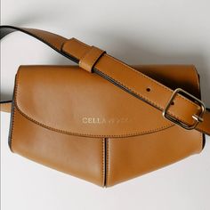 A Chic Accessory For The Woman On-The-Go. The Tan Belt Bag Is An Elegant And Pretty Fanny Pack, In A Modern And Compact Form. It Is The Perfect Size To Fit Your Phone, Wallet And Keys. Its Adjustable Waist Belt Strap Enhance Both Its Modern Feel And Its Practicality, As It Can Be Worn Around The Waist When With Kids On The Go. Details: Leather Exterior 8" Length X 6.5" Height X 4" Depth Removable And Adjustable Belt - Can Be A Clutch Or Belt Bag. Elegant Belt Bag With Removable Pouch For Shopping, Rectangular Leather Belt Bag For Shopping, Cognac Bag With Magnetic Closure For Everyday Use, Cognac Bag With Magnetic Closure, Leather Belt Bag With Removable Pouch For Shopping, Cognac Shoulder Bag With Magnetic Closure, Cognac Crossbody Bag With Magnetic Closure, Cognac Travel Bag With Magnetic Closure, Chic Gold Leather Saddle Bag