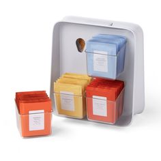 the four containers are filled with different colored teas