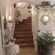 an entry way with stairs and potted plants