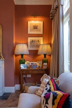 a living room filled with furniture and two lamps on top of it's side tables