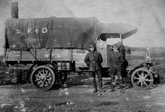 two men standing next to an old truck