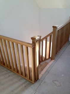 a wooden banister next to a white wall