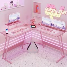 a pink desk with two computer monitors on top of it and a keyboard in the middle