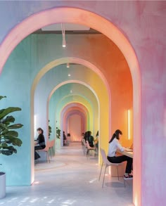 people are sitting at tables in a brightly colored hallway