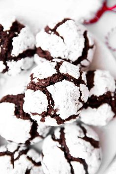 chocolate crinkle cookies are piled on top of each other with powdered sugar