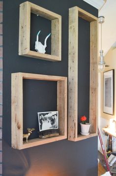 two wooden shelves with pictures on them against a black wall in a living room or dining room