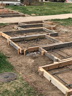 the foundation for a house being built in front of a yard with grass and dirt