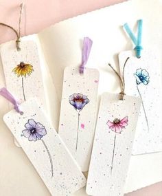 three tags with flowers painted on them