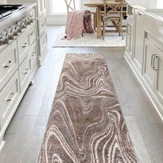 a kitchen with white cabinets and an area rug on the floor