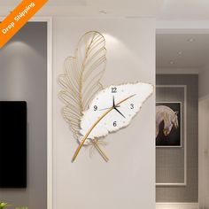 a clock that is on the wall next to a plant in a room with white walls