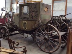 an old fashioned horse drawn carriage in a warehouse