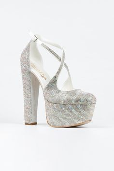 a women's white high heeled shoe with straps and glittery fabric on the platform