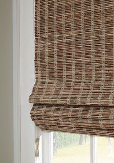 a window with roman blinds made out of bamboo