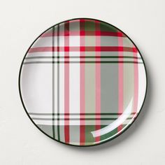 a green and red plaid plate on a white wall