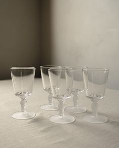 four wine glasses sitting on top of a table