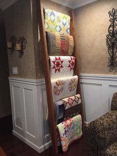 a ladder that is holding quilts in it