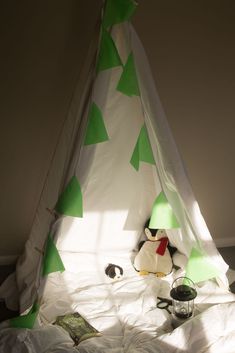 a stuffed penguin sitting in front of a teepee