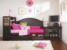 a bedroom with a fuchsia pink couch and white rug