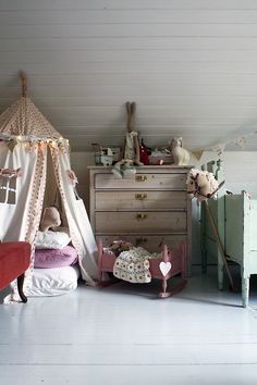 a child's bedroom with a teepee tent, dresser and bed