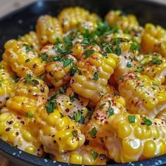 corn on the cob with herbs and seasoning in a black bowl