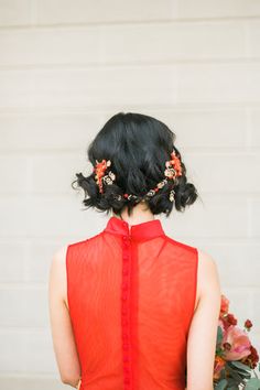 a woman wearing a red dress with flowers in her hair