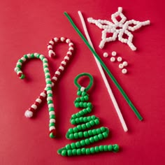 green and white beaded christmas decorations on a red surface with candy canes, snowflake ornament