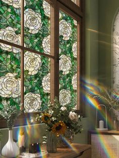 the sun shines through stained glass windows in a bathroom with flowers and vases