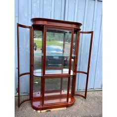 a wooden corner display case with glass doors