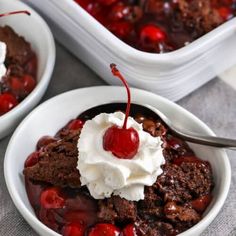 two white bowls filled with ice cream and cherry pie desserts on top of a table