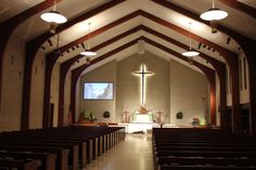 the inside of a church with pews and lights