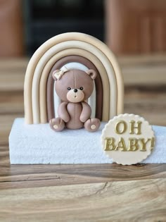 a teddy bear sitting on top of a towel next to a sign that says oh baby