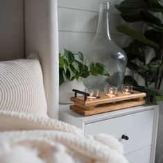 candles are placed on a tray in front of a bed