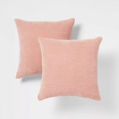 two pink pillows sitting next to each other