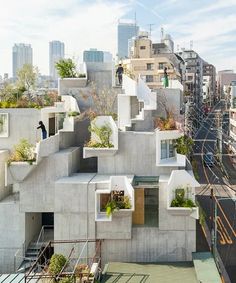 an apartment building with plants growing on the roof and in the middle of it's walls