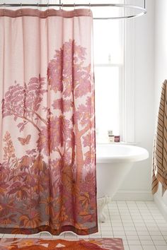 a bathroom with a pink shower curtain next to a bath tub