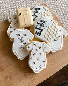 decorated cookies on a cutting board with words and pictures in the shape of baby ones