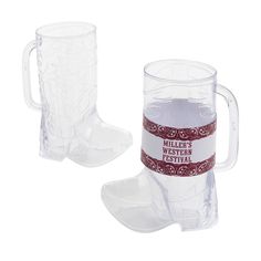 two clear glass mugs with red ribbon around the bottom, one has a cowboy boot design on it