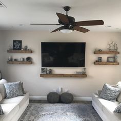 a living room with two couches and a flat screen tv mounted on the wall