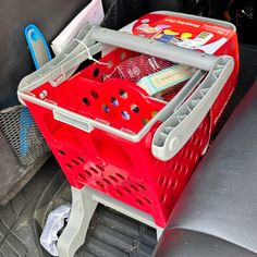 a red shopping basket sitting in the back seat of a car