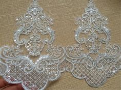 two pieces of white lace sitting on top of a table