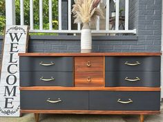 an old dresser is painted black and brown